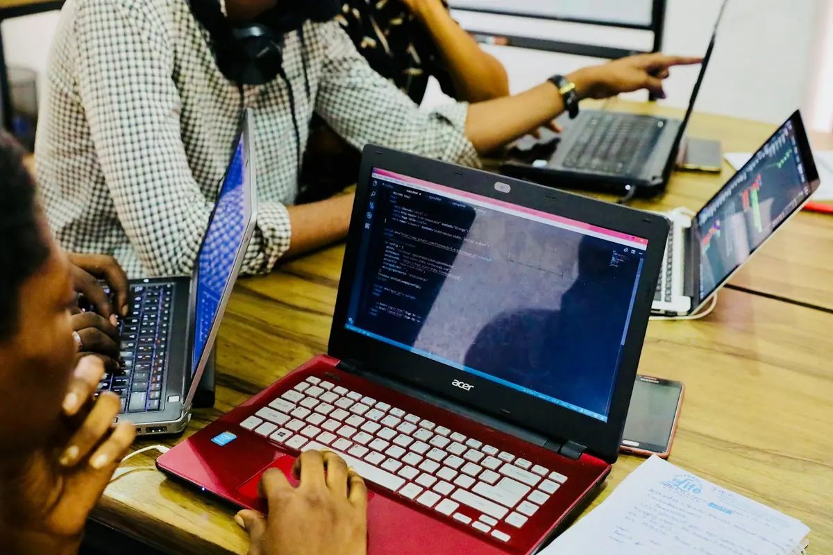Une personne travaille sur un ordinateur portable dont l'écran affiche du code